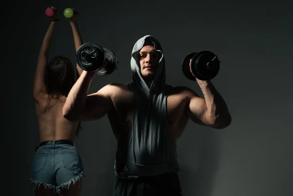 Сексуальна спортивна пара займається з гантелі. Тонка і здорова сексуальна дівчина з сильним тренуванням м'язистого чоловіка . — стокове фото