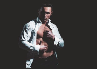 Yakışıklı, erkek model, beyaz gömlekli. Modaya uygun bir adamın stüdyo fotoğrafı. Seksi, muhteşem, stil sahibi adam..