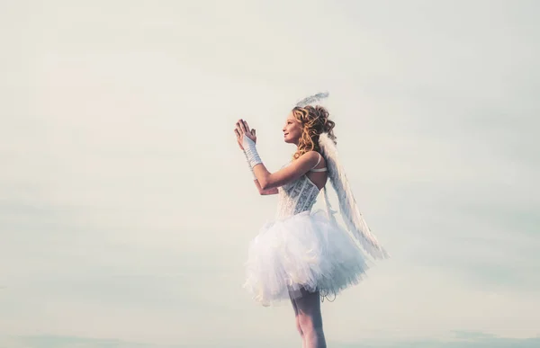 Ευτυχισμένο εφηβικό κορίτσι άγγελος προσευχηθείτε. Παιδί με αγγελικό χαρακτήρα. Κορίτσι ντυμένη σαν άγγελος σε ένα φως παράδεισο φόντο. Χερουβείμ. Γλυκιά Αγγελική κοπέλα. Ημέρα του Αγίου Βαλεντίνου κάρτα. — Φωτογραφία Αρχείου