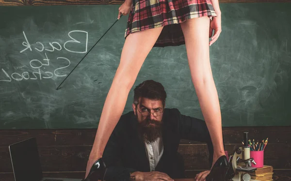 Role love game back to school. Anatomy lesson and sex education in high school. Sexy young schoolgirl in plaid skirt and long legs standing at teachers desk. Young sexy teacher. — Stock Photo, Image