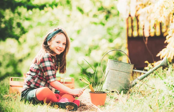 I like spending time on farm. Little helper in garden. Happy little gardener with spring flowers. Happy childhood concept. — Stock Photo, Image