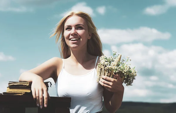 Ritratto di una bella ragazza bionda in primavera. Giovane donna che tiene mazzo di fiori di campo nella natura. Concetto di primavera. — Foto Stock