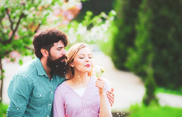 Ein verliebtes romantisches Paar, das Glück empfindet. Junges reizendes Paar beim Spaziergang im Frühlingspark. Lächelndes verliebtes Paar auf blühendem Baumgarten-Hintergrund. — Stockfoto