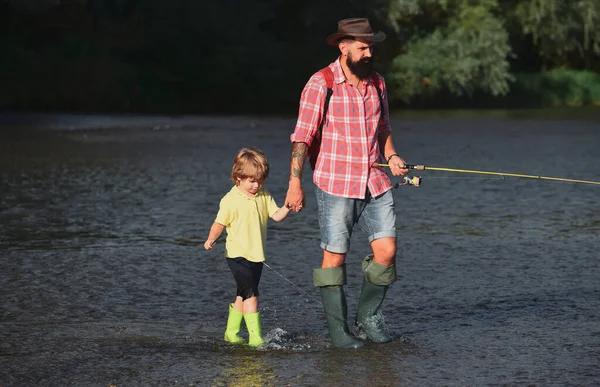 Concetto di famiglia felice - padre e figlio insieme pescando. Buon padre e figlio pesca con canne da pesca. — Foto Stock