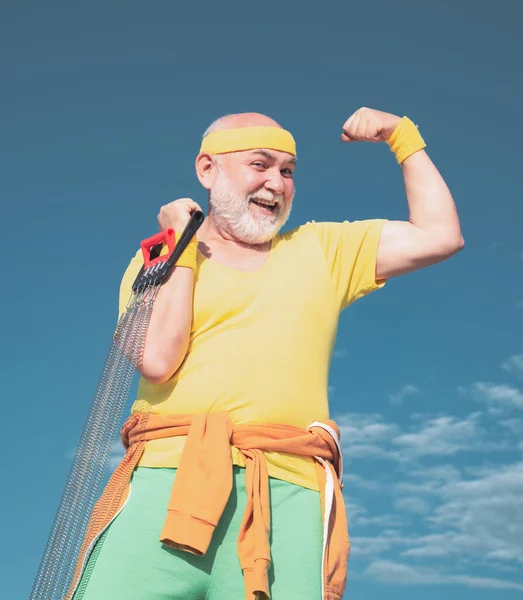 Fit senior man resting after working out. Exercising. Freedom retirement concept. Elderly man practicing sports on blue sky background. — Stock Photo, Image