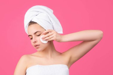 Süngerle yanağa dokunan güzel kadın, sağlıklı doğal ten. Kafasında banyo havlusu olan çekici bir genç kızın portresi. Güzel kadın portresi.