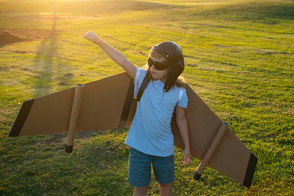 Barn ledare och vinnare, framgång starta upp. Spännande barn pojke leka med leksak jetpack vingar superhjälte i parken. Drömmer, frihet och resande koncept. — Stockfoto