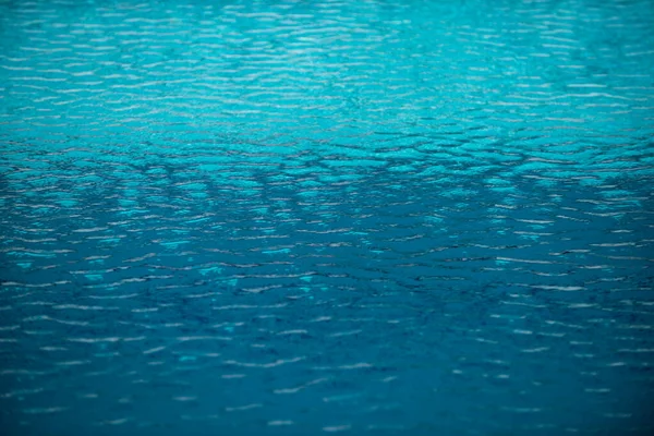 Agua rasgada azul en la piscina, textura de la piscina de agua y fondo de agua superficial. — Foto de Stock