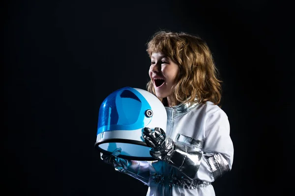 宇宙飛行士のヘルメットの衣装を着た少年。宇宙飛行士のかわいい子供は宇宙飛行士になる夢を見て. — ストック写真