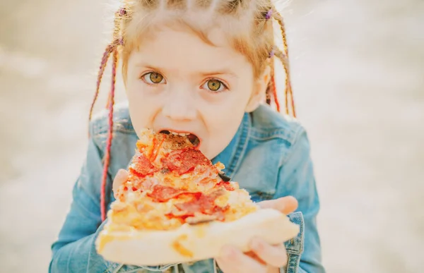 Pizza yiyen tatlı kız. Çocuklar fast food yapar. İtalyan mutfağı. Çocukluk kavramı. — Stok fotoğraf
