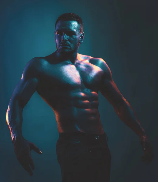 筋肉質の身体と裸の胴を持つセクシーな男。青いネオンライト. — ストック写真