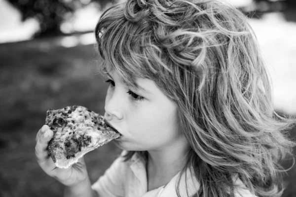 Çocuk bir dilim pizza yiyor. Çocuk bir dilim pepperonili pizza yedi. Komik çocuk suratı. Pizza en iyi yemektir. Tatlı küçük çocuk pizza yiyor.. — Stok fotoğraf