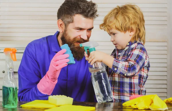Pappa och son med städutrustning. Far har roligt med barn och städa huset. Människan vänjer pojken vid renlighet. — Stockfoto