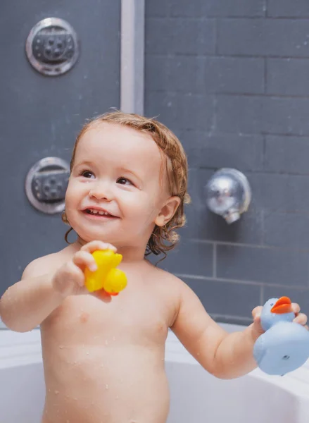 Kind unter der Dusche. Niedliche Baby Junge genießen Bad und gebadet im Badezimmer. — Stockfoto