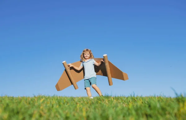 Menino criança com asas no céu imagina um piloto e sonhos de voar. — Fotografia de Stock