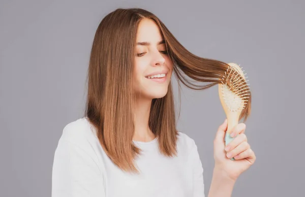 髪を磨く。櫛でまっすぐ自然な髪をブラッシング肖像若い笑顔の女性。ヘアブラシで髪を持っている女の子。ヘアケア美容コンセプト. — ストック写真