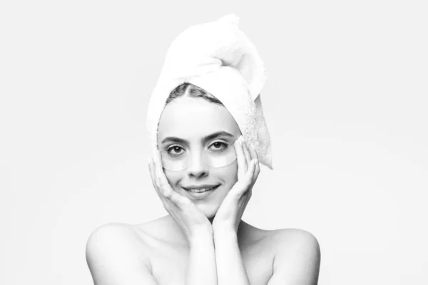 Γυναίκα που βάζει μπαλώματα στα μάτια. Πορτρέτο κορίτσι ομορφιά με πετσέτα στο κεφάλι. — Φωτογραφία Αρχείου
