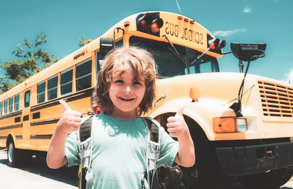 Glückliches Schulkind. Kind aus der Grundschule mit Tasche im Schulbus. Erfolgs-Zeichen macht positive Geste mit der Hand, Daumen hoch lächelnd und glücklich. — Stockfoto