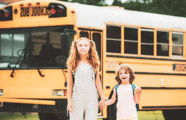 Eine Gruppe kleiner Kinder steigt in den Schulbus. — Stockfoto