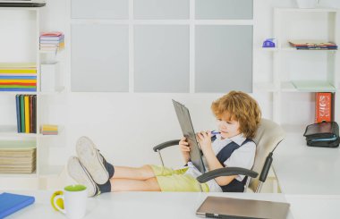 Kendine güvenen küçük işadamı çocuk. Ofiste çalışan sevimli bir çocuk işadamı..