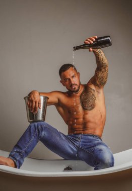 Seksi baştan çıkarıcı soyunan adam banyoda küvete oturur, erkekler şampanya ile tatil yapar. Noel 'i ya da doğum gününü kutlamak için. Özel seks partisi.