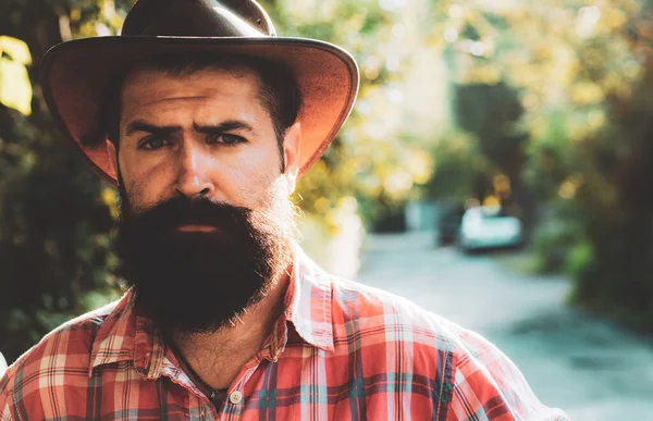 Jeune homme beau chapeau de cow-boy avec longue barbe, moustache et coiffure tendance. — Photo