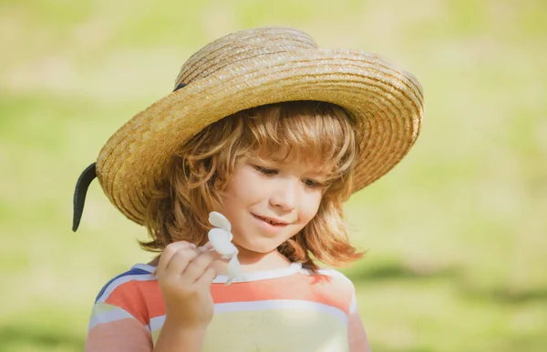 Ritratto per bambini, testa di bambino carino in cappello di paglia con fiore di plumeria. — Foto Stock