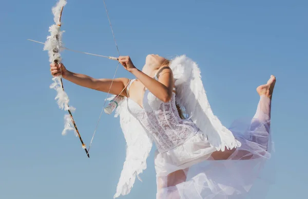 弓と矢を持つセクシーな官能的な天使。白いドレスを着たキューピッドの女の子。甘い天使の少女の肖像画。ハッピーバレンタインデー. — ストック写真