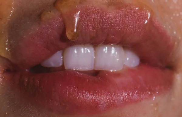 Женский рот с сексуальными розовыми губами изолирован крупным планом. Закройте женские чувственные губы красной помадой. Страстная губа. Мед на губах сексуальной девушки. Моделирующий нектар. — стоковое фото