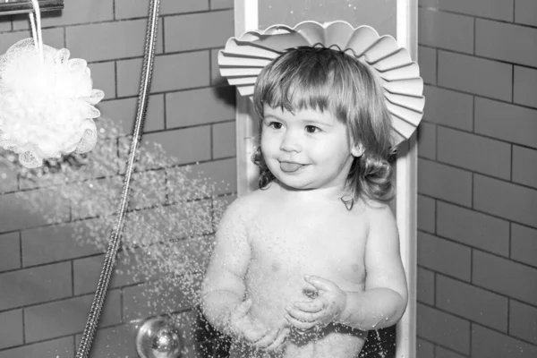 Kleines Kind badet in Seifenlauge. Lustiges Baby, das zu Hause in Schaum gebadet und in Badewanne gewaschen wird. — Stockfoto
