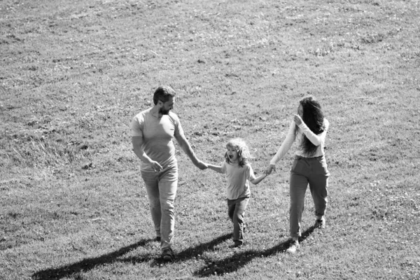 公園の外で子供と一緒に歩く幸せな若い両親。家庭生活における幸福と調和. — ストック写真