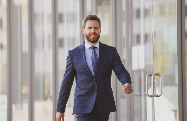 Businessman walking in city. Confident and successful. Handsome business man while walking outdoors near office building.