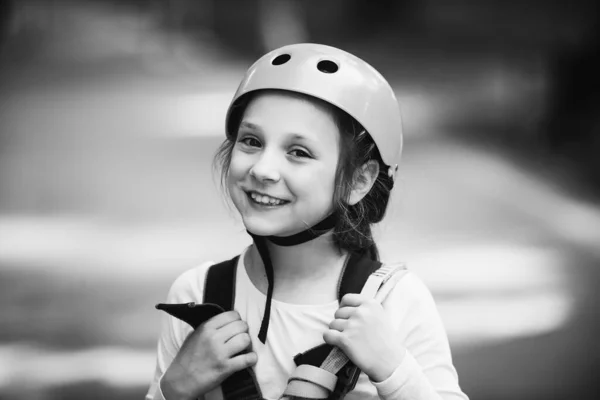 Bambina che si arrampica nel parco avventura con casco e attrezzatura di sicurezza. Ragazzina che si arrampica sul parco ad alta fune. Casco e attrezzature di sicurezza . — Foto Stock