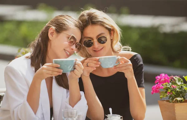 Amigas no café ao ar livre. Ao ar livre retrato de duas mulheres bonitas jovens amigos bebendo café. — Fotografia de Stock
