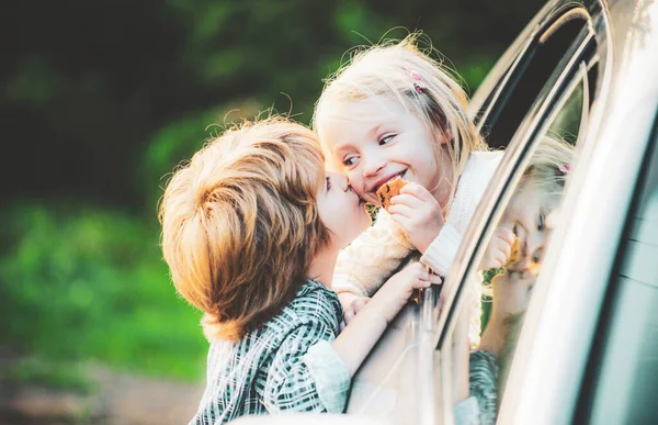 Delighted happy smiling little girl says goodbye to little boyfriend who sails for long time. Gives warm kiss. Couple saying goodbye before car travel. — Stock Photo, Image