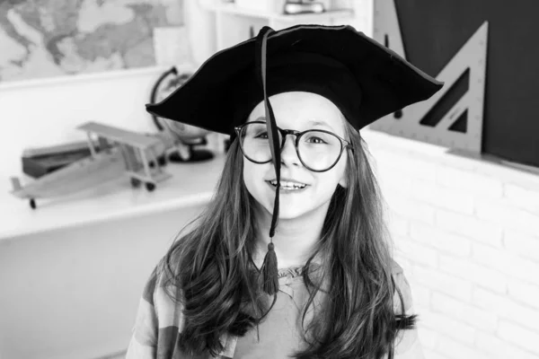 Divertente studentessa con il cappello da laurea. Bambino delle elementari. Scuola media. — Foto Stock