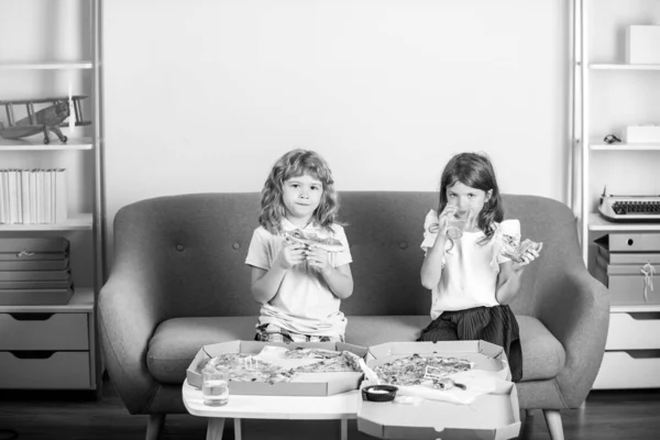 Vicces gyerekek pizzát esznek. Két kisgyerek pizzát eszik idebent.. — Stock Fotó