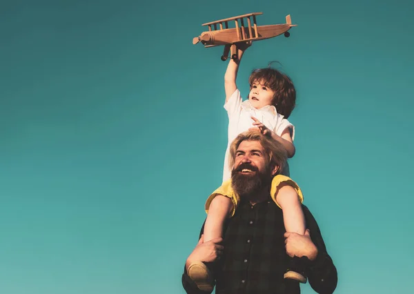 L'enfant est assis sur les épaules de son père. Enfant jouant imagination avion volant de rêve, concept de jour des enfants. Père et fils. Parent avec enfant garçon. — Photo