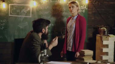 Öğretmen ve üniversite öğrencisi sınıfta. Üniversitede ödev yapmayı düşünen bir kız öğrenci. Profesör öğretmenlik konsepti. Akıl hocası, koç, öğretmen kadın, iş arkadaşıyla konuşuyor..