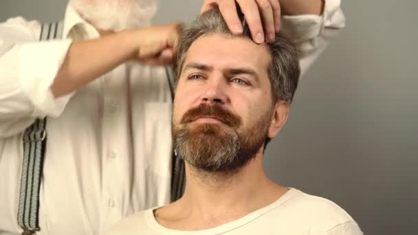 Parrucchiere con pettine in barbiere. Barbiere fare taglio di capelli a uomo attraente in barbiere. — Video Stock