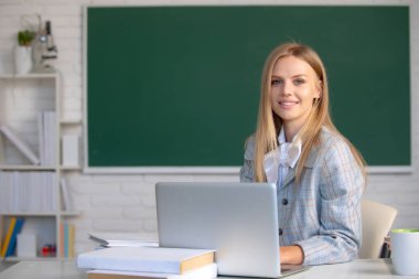 Odaklanmış öğrenci, internette genç bir kadın dizüstü bilgisayarda webinar izliyor, eğitim kurslarını dinliyor, sınıftaki çalışma masasında oturuyor, konsept öğreniyor. Çevrimiçi webinar, video uzaklık öğrenme çağrısı.