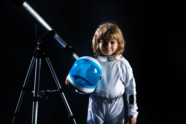 Petit garçon portant un costume d'astronaute et un télescope. Joli gamin astronaute jouant et rêvant de devenir astronaute. Concept d'astronomie et d'astrologie. — Photo