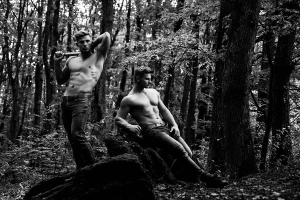 Mužská síla. Svalnaté mužské modelky bez trička a džínové kalhoty. Módní brutální kluci se sexy nahý trup v lese. — Stock fotografie