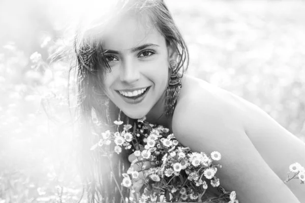 Портрет красивої молодої дівчини навесні з польовими квітами. Щасливе літо обличчя молодої жінки в зеленому полі природи . — стокове фото