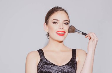 Güzel bir kadın modelin güzel portresi. Güzel yüzlü kadın, doğal ten, yüz derisi, makyaj fırçasıyla allık sürüyor..