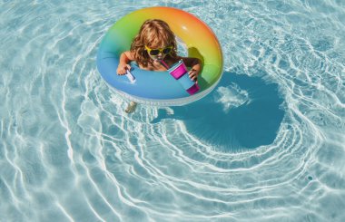 Yaz zamanı yüzme yüzüklü ve güneş gözlüklü havalı çocuk. Yaz çocukları hafta sonu ya da tatil. Havuzdaki komik mutlu çocuk şişirilebilir lastik halka üzerinde.