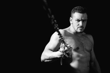 Mükemmel erkek vücudu. Adam zincir tutuyor. Siyahta izole edilmiş. Boşluğu Kopyala.