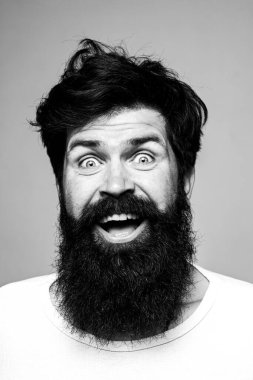 Heyecanlı, yakışıklı bir genç. Gri duvara karşı memnun iş adamının portresi. Olumlu insan yüz ifadeleri ve duyguları.