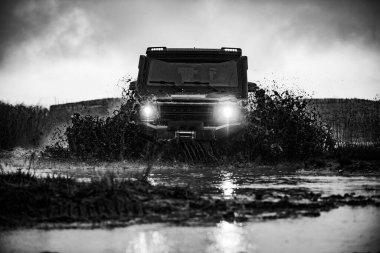 Offroad vagonu kötü yolda. Dağ yolundaki köylere yapılan off-road cipi seferi. Off-road yarışında çamur ve su sıçraması. Offroad vagonu.