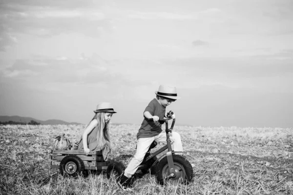 Dışarıda oynayan ve bisiklete binen aktif bir çocuk. İki çocuk mavi gökyüzü arka planıyla sahada eğleniyor. Dünya günü. Eko çiftliği. İki genç çiftçi. Kızı ve oğlu çiftlikte çalışıyor.. — Stok fotoğraf